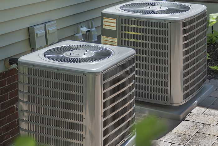Two heat pumps outside home.