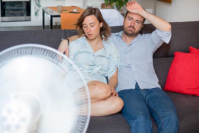 Overheated couple sitting on couch