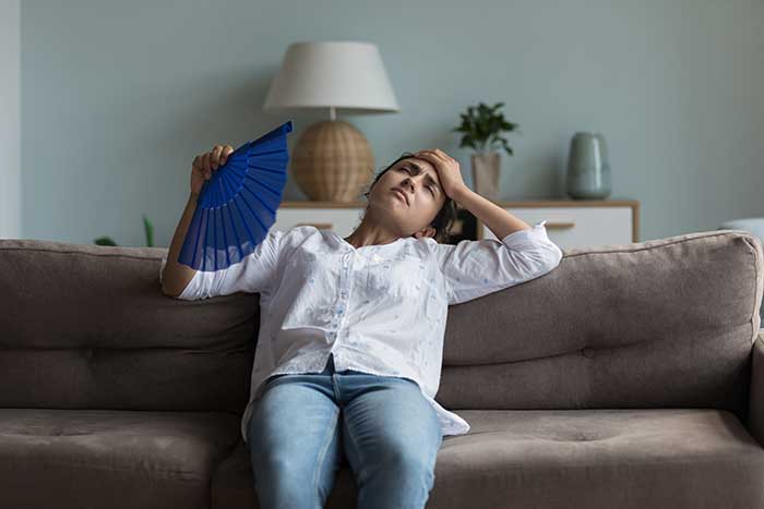 Woman suffering in warm room