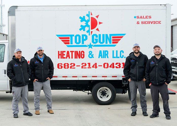 Top Gun crew beside truck.